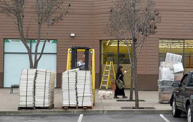 A woman walks her dog outside an empty Dollar Tree store in Marin City, Calif. on Thursday, Jan. 28, 2016. (Alan Dep/Marin Independent Journal) 